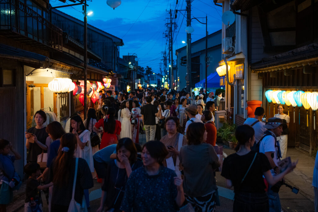 夜の通りを歩く来場者